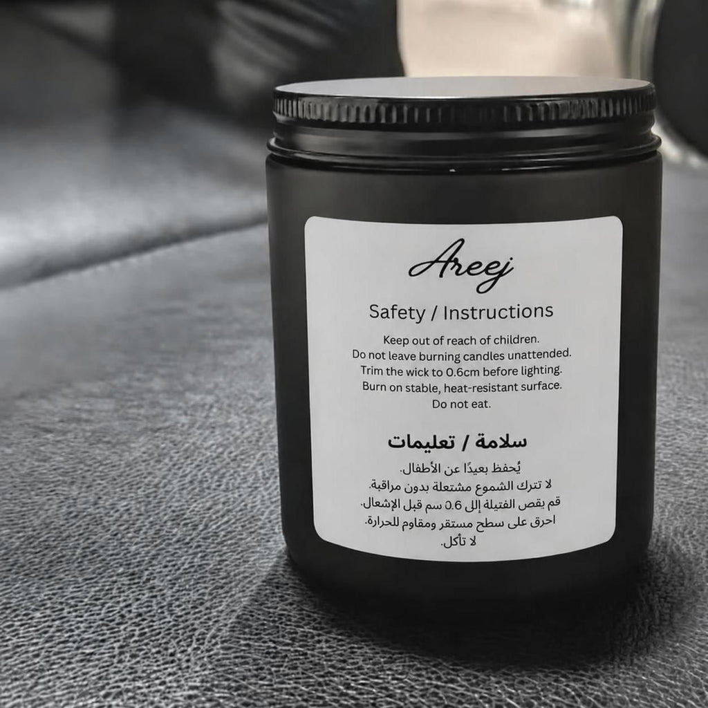 Back side of Areej oud candle jar with a label on a textured surface